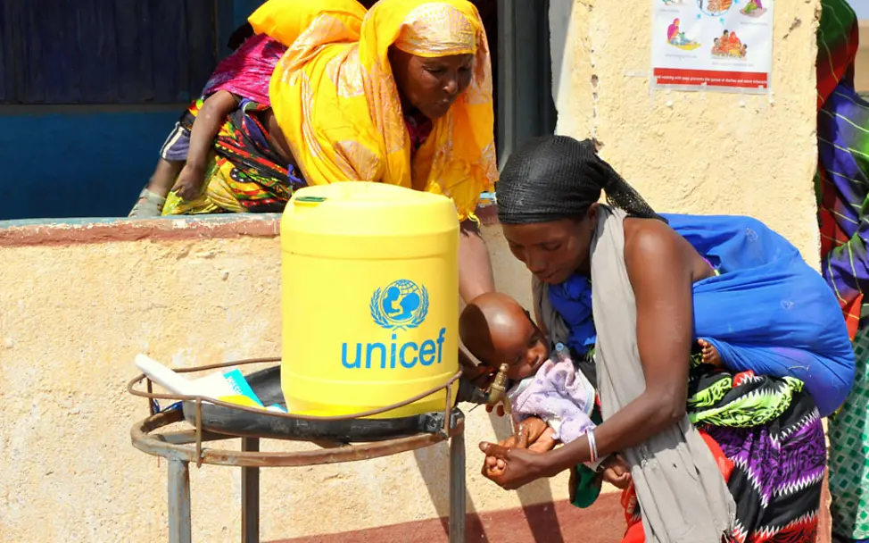 Bevor sie ihr Kind füttert, wäscht sich diese Mutter noch die Hände | © UNICEF/Oloo Kenia: Eine mutter wäscht sich ihre Hände
