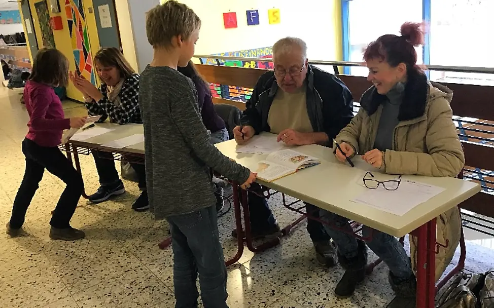 Alle Beteiligten sind begeistert von der Aktion | © UNICEF/Ursula Grass Lesen für UNICEF: Zusammen wird das Leseprotokoll durchgegangen