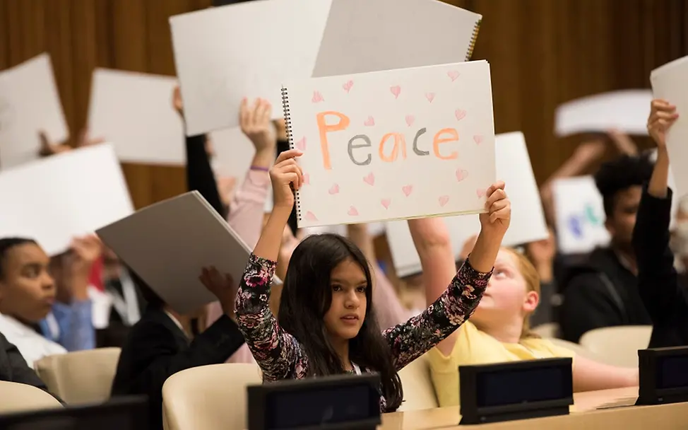 Mädchen mit Friedensbotschaft | © UNICEF/Markisz Ohne Angst für Menschenrechte und Demokratie: Mädchen hält Friedensbotschaft hoch