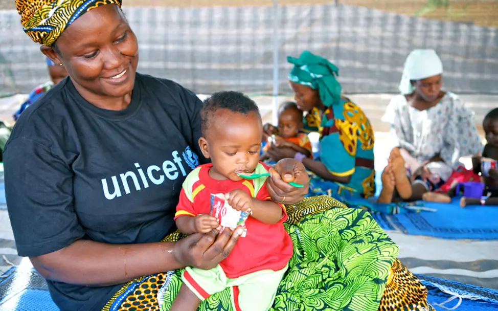 Eine UNICEF-Helferin in Niger füttert ein Baby mit Erdnusspaste | © UNICEF/Pirozzi Niger: Eine UNICEF-Helferin füttert ein Baby mit Erdnusspaste