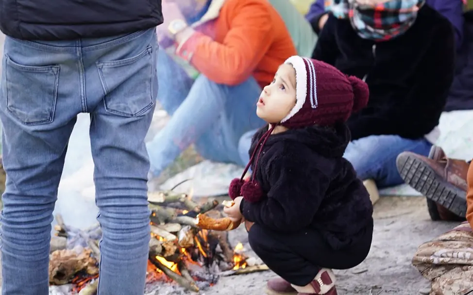 Türkei/Edirne: In der Nähe der griechisch-türkischen Grenze. | © UNICEF/Turakoglu, ASAM Türkei 2020: Ein Kleinkind hockt auf dem Boden vor einem Lagerfeuer.
