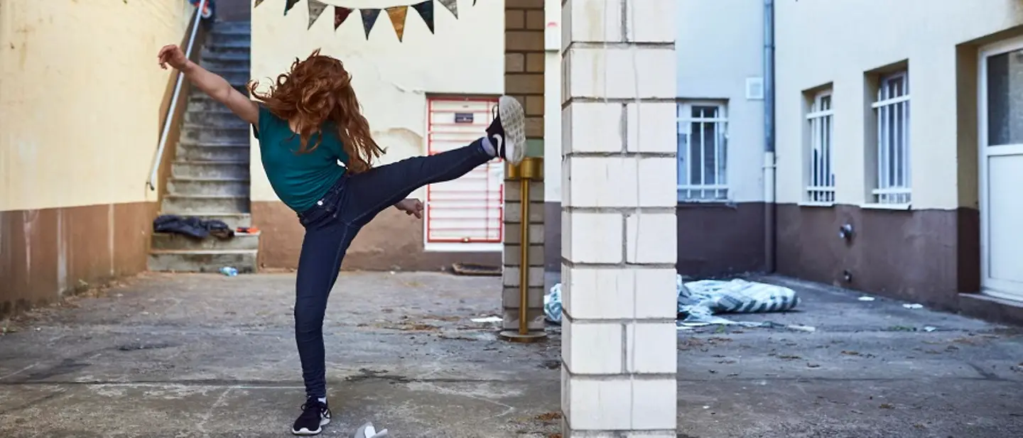 Der Spaß darf auch in Zeiten von Corona nicht fehlen. | © UNICEF/Bänsch Kindererziehung: Ein Mädchen tritt schwungvoll in die Luft.