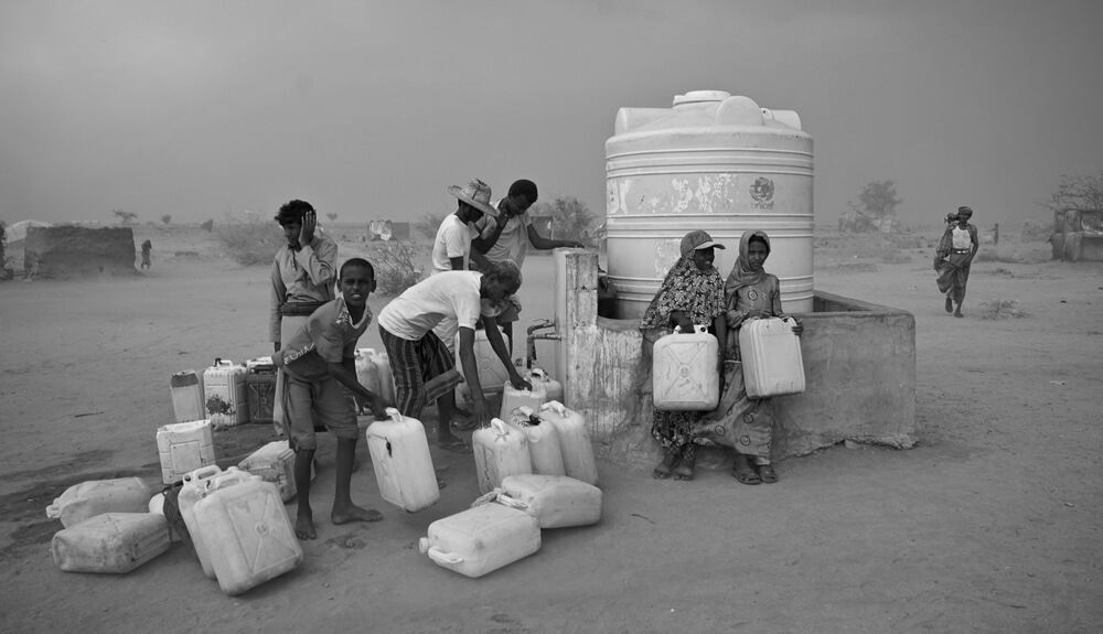 Geflüchtete Kinder beim Wasserholen an einem Wassertank von UNICEF | © Giles Clarke for UNOCHA Jemen: Kinder am Wassertank von UNICEF