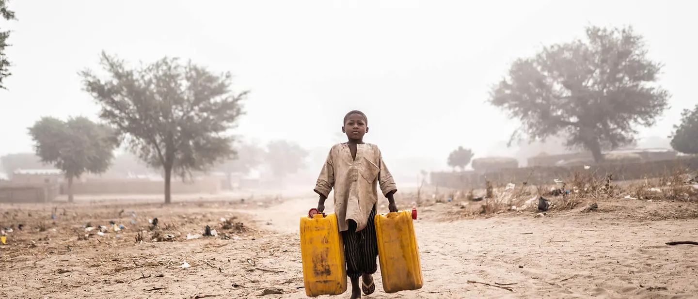 Ein Junge beim Wasserholen für seine Familie in Niger | © UNICEF/Haro Spenden, wo es am Nötigsten ist: Ein Junge beim Wasserholen in einer trockenen Landschaft