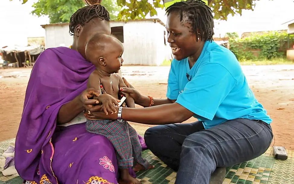 Akot mit Helferin und Mutter | © UNICEF/Wilson Akot mit Helferin und Mutter