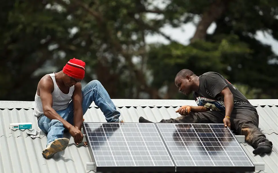 Sierra Leone: Techniker installieren Solarzellen. | © UNICEF/Asselin Sierra Leone: Techniker installieren Solarzellen.