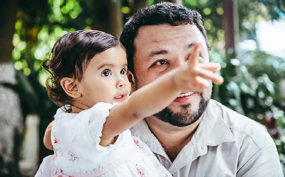 Klimawandel: So sprechen Sie mit Kindern darüber | © UNICEF/Willocq Klimawandel für Kinder erklärt: Ein kleines Mädchen zeigt ihrem Vater einen Vogel im Baum.