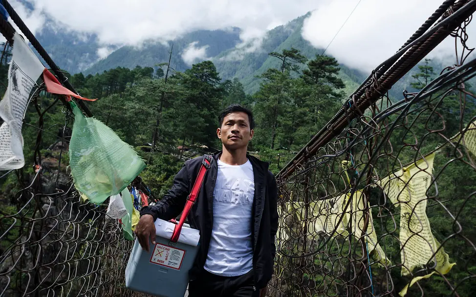 Dematso Khamblai überquert die Hängebrücke mehrmals täglich, um Menschen mit wichtigen Impfstoffen zu versorgen. | © UNICEF/Bannerjee VII Photo Dematso Khamblai arbeitet als Gesundheitsimpfer für UNICEF in Indien.