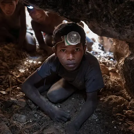 Sambilahatsa arbeitet tief unter der Erde in einer Glimmermine. | © UNICEF/Andrianantenaina Kinderarbeit: Sambilahatsa hockt mit Stirnlampe in der Glimmermine Vohibola in der Region Anosy, 15 Meter unter der Erde.