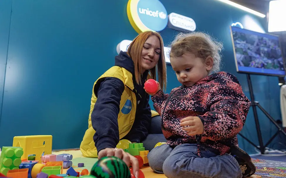 Eine UNICEF-Mitarbeiterin spielt mit einem Mädchen in einem geschützten Raum für Kinder | © UNICEF/Skyba Kinder im Ukraine-Krieg: In speziellen Kinderzentren können Kinder trotz Luftalarm und Angriffen in Ruhe spielen.