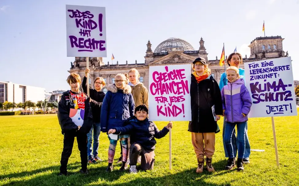 Demokratie braucht Nachwuchs: Gemeinsames Engagement für Kinderrechte |© UNICEF/Zimmermann Kinderrechte leben: Kinder stehen mit Demo-Plakaten vor dem Reichstag.