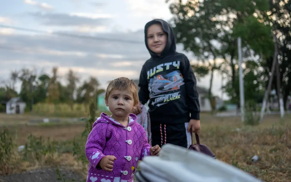 Ukraine | © UNICEF/UNI655411/Filippov Die einjährige Faina steht zusammen mit ihrem Bruder Timur (5) an der Bushaltestelle im Dorf Dachne.