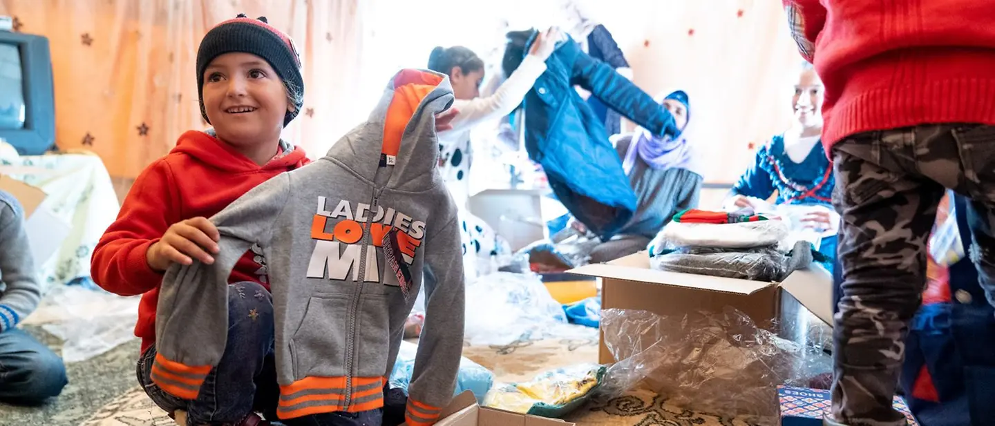 Mit Ihrer Weihnachtsspende UNICEF-Hilfspakete ermöglichen | © UNICEF/Herwig Mit Ihrer Spende zu Weihnachten helfen: Mädchen packt UNICEF-Hilfspaket aus.