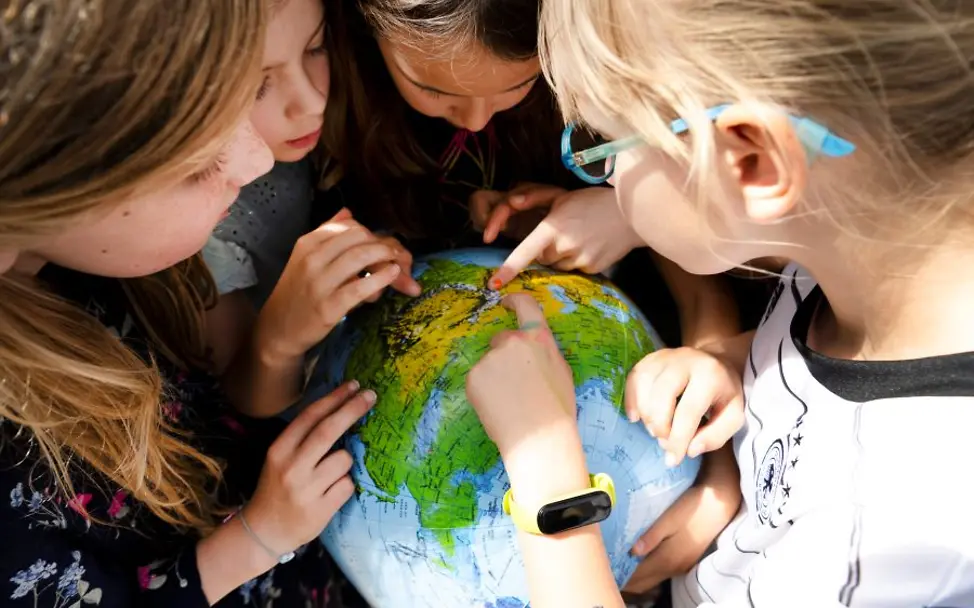 Kinder lernen Kinderrechte kennen. | ©UNICEF/Etges Vier Mädchen schauen sich gemeinsam einen Globus an.