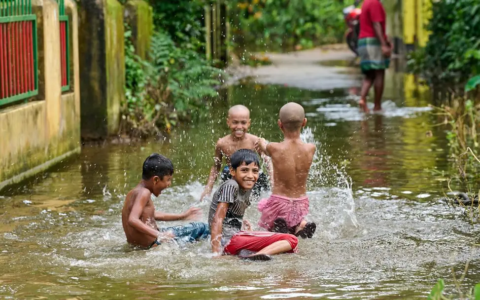 Klimawandel erklären: Kinder spielen in überschwemmten Straßen. | © UNICEF/Sujan Klimawandel für Kinder erklärt: Kinder Bangladesch Überschwemmung