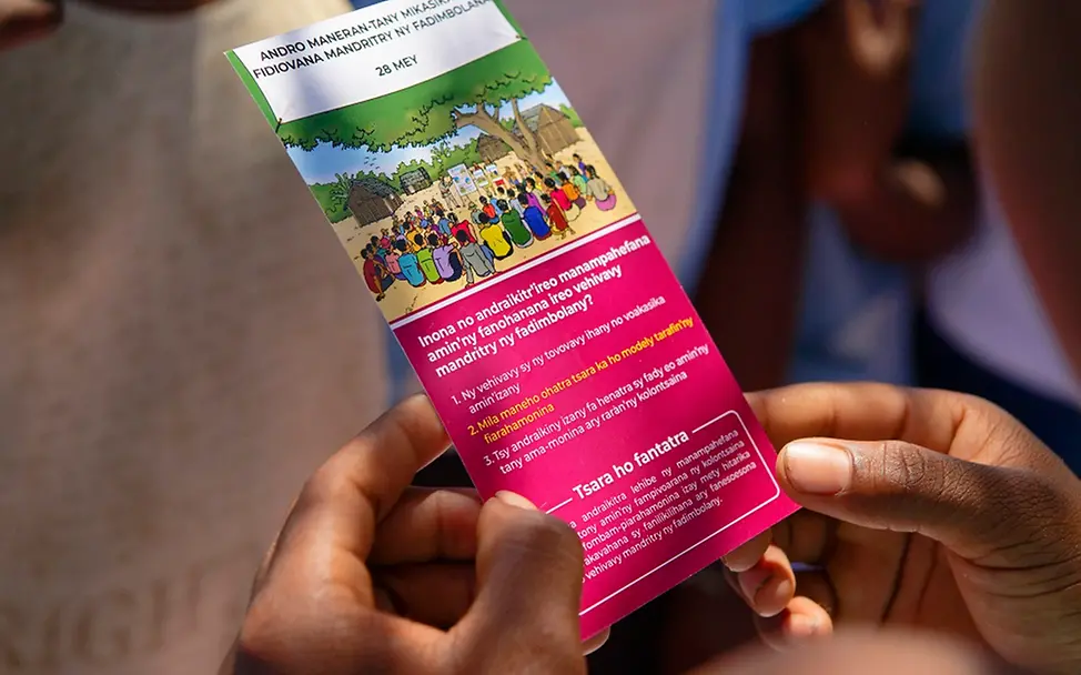 Informationsmaterial zum Thema Menstruation. | UNICEF/Ramasomanana Menstruation: Ein Mädchen hält eine Broschüre in der Hand