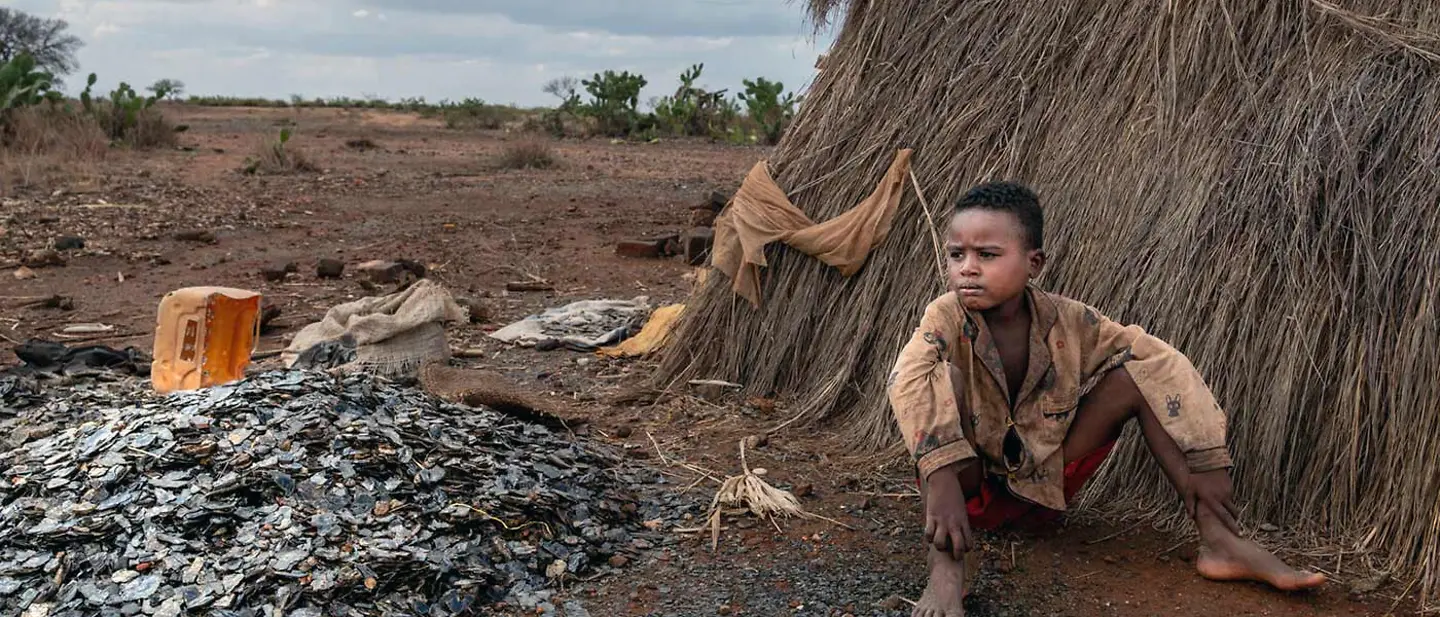 Spenden gegen Kinderarbeit: UNICEF unterstützt Kinder wie diesen in einer Mine arbeitenden Jungen | © UNICEF/Andrianantenaina Der 8-jährige Tsifeheza sitzt neben dem Eingang zur Glimmermine auf dem Boden und schaut in die Ferne.