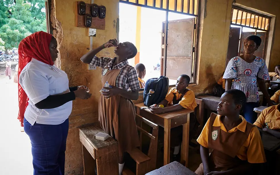 Eine Schülerin nimmt eine Eisen-Folsäure-Tablette ein.| © UNICEF/Noorani Menstruation: Eine Schülerin nimmt eine Eisen-Folsäure-Tablette ein.