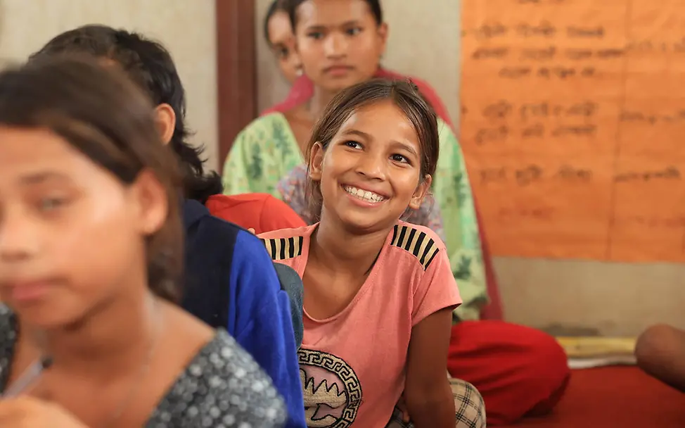 Ein Mädchen in Nepal sitzt lächelnd in einem von UNICEF aufgebauten Kinderzentrum | © UNICEF/Laxmi-Prasad-Ngakhusi Kinderarmut spenden: Ein Mädchen in Nepal sitzt lächelnd in einem von UNICEF aufgebauten Kinderzentrum.