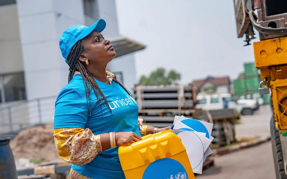 Eine UNICEF-Helferin in Kinshasa hilft beim Ausladen von UNICEF-Hilfsgütern. | © UNICEF/UNI860564/ Ebola Kongo: Beim Ebola-Ausbruch 2025 unterstützte UNICEF Kinder und Familien mit Hilfsgütern.