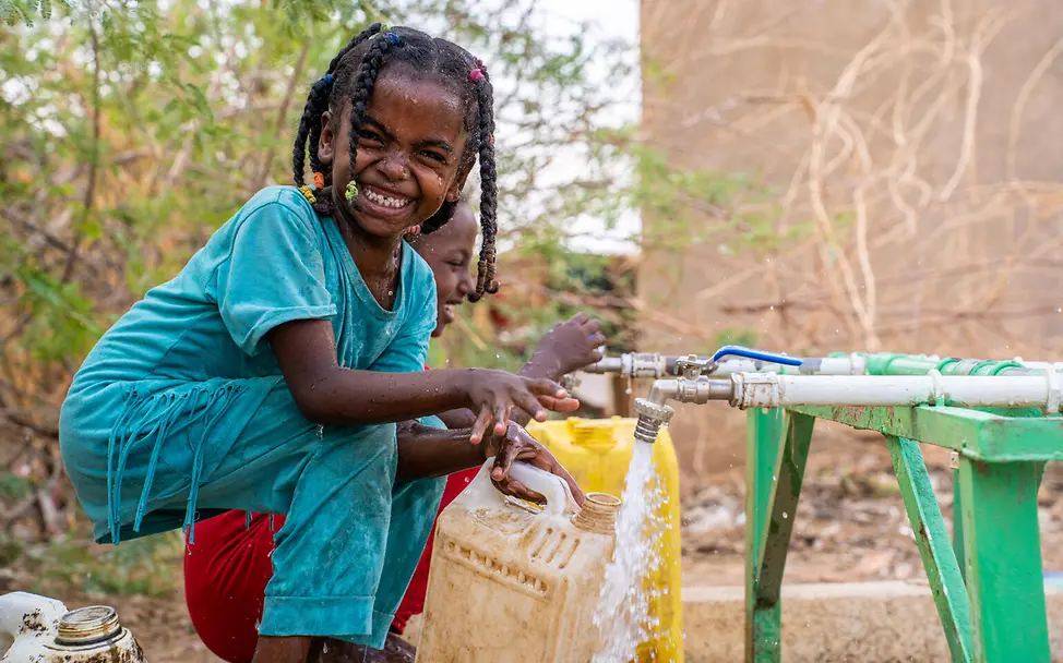 Ein Mädchen füllt an einer Wasserstelle sauberes Wasser in einen Kanister | © UNICEF/Rajab Sudan Krieg: Ein Mädchen füllt an einer Wasserstelle sauberes Wasser in einen Kanister.