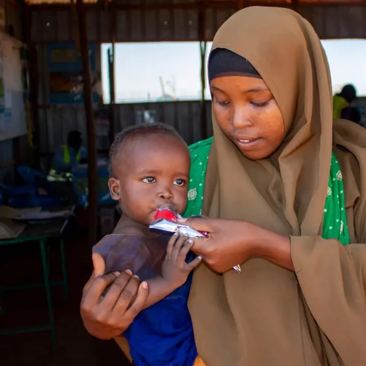 Somalia Hungerkrise: Nährstoffreiche Erdnusspaste hilft den mangelernährten Kindern, zu Kräften zu kommen. | © UNICEF/Hill Somalia Hungerkrise: Ein Kleinkind bekommt von seiner Mutter Spezialnahrung zur Behandlung gegen Mangelernährung.