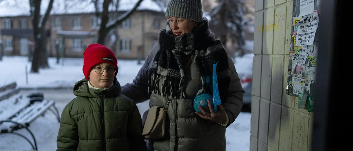 Winter in der Ukraine: Ein Junge steht in Kiew mit seiner Mutter in einem Hauseingang | © UNICEF/Filippov Ukraine Krieg: Der Winter bringt die Kinder zusätzlich in Gefahr