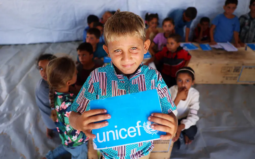 Der 10-jährige Ibrahim hält sein UNICEF-Schulheft in den Händen. | © UNICEF/Nateel Gaza spenden: Ein Junge zeigt in einem Lernzentrum sein UNICEF-Schulheft.