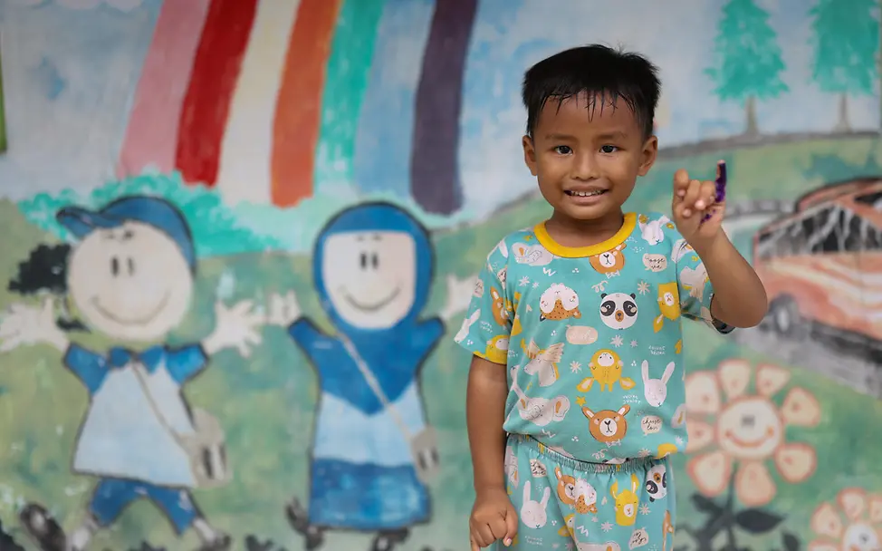Muhammad (4) nach seiner Polio‑Impfung in Zentraljava. | © UNICEF/Prasetya Ein vierjähriger Junge lächelt in die Kamera, nachdem er im Dorf Banjardawa in Zentraljava eine Polio‑Impfung erhalten hat.