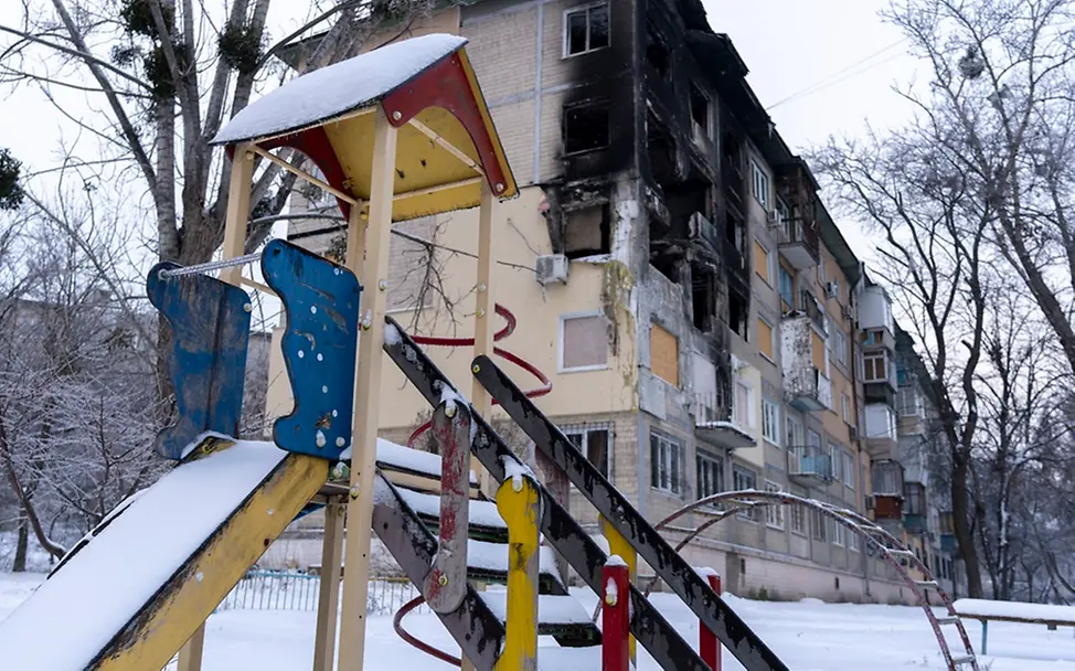 Vier Jahre Krieg haben große Zerstörung verusacht | UNICEF/Filippov Ukraine: Ein Spielplatz vor einem zerstörten Gebäude