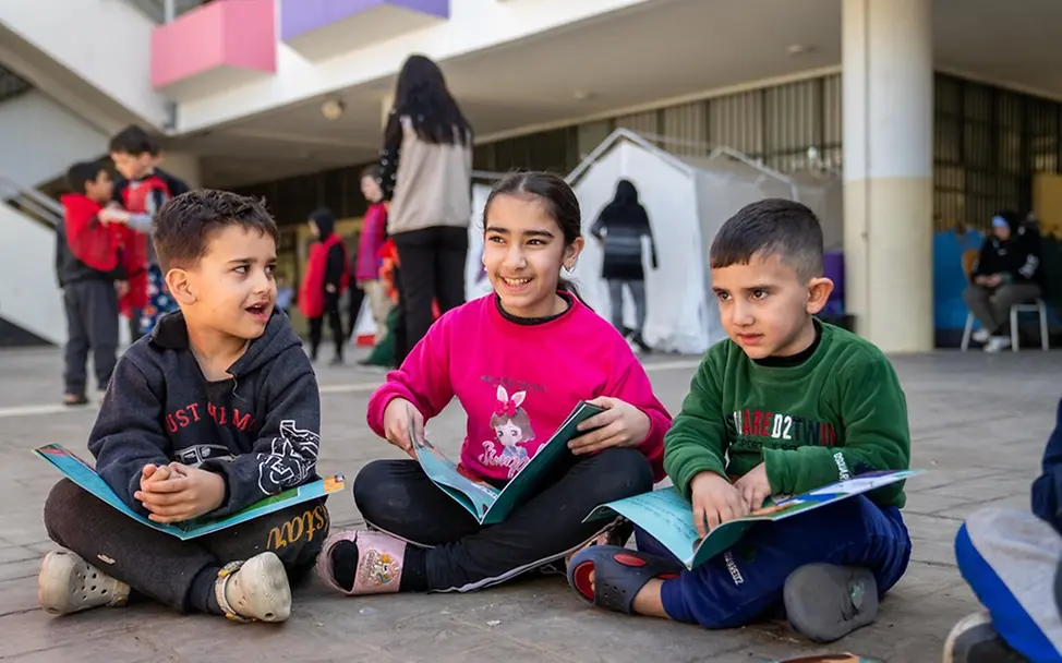 Asil (11) liest mit Freunden in einer Notunterkunft. | © UNICEF/Choufany Leben im Libanon: Asil (11) liest mit Freunden in einer Notunterkunft.