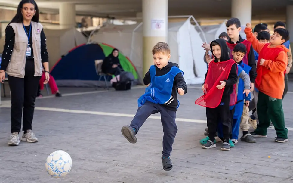 Kinder lachen und spielen in einer Notunterkunft Fußball. | © UNICEF/Choufany Leben im Libanon: Kinder lachen und spielen in einer Notunterkunft Fußball.