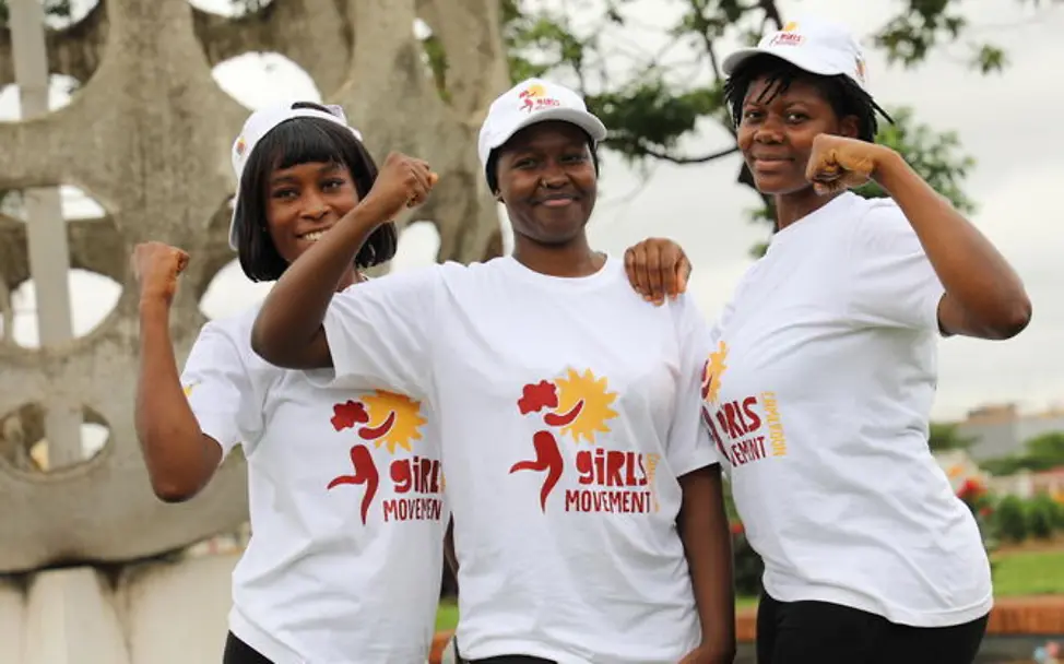 Aids einfach erklärt: UNICEF unterstützt Programme, um Mädchen zu stärken. | © UNICEF/Beguel Aids einfach erklärt: Drei junge Frauen posieren in Shirts und Kappen von „Girls Movement“.