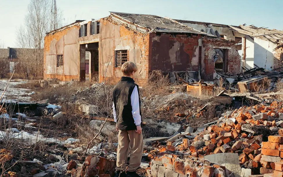 Roman (13) schaut auf die Trümmer eines Kinderzentrums und eines Cafés. | © UNICEF/Kruchkova Roman (13) schaut auf die Trümmer eines Kinderzentrums und eines Cafés.