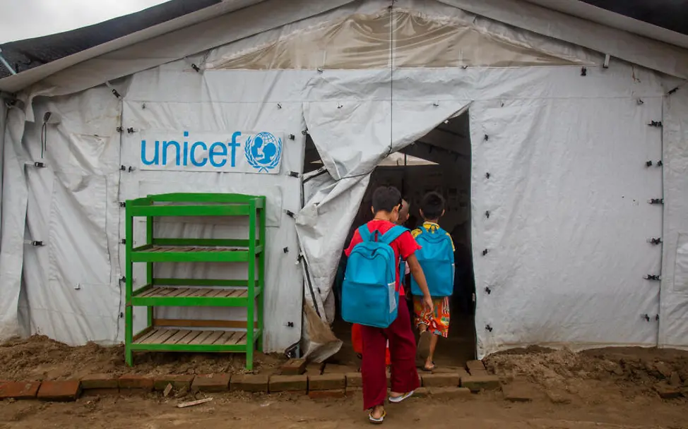 Wenn Schulen durch Naturkatastrophen zerstört werden, sind die Kinder auf Notschulen angewiesen. | © UNICEF/Htet Erdbeben einfach erklärt: Kinder gehen zum Unterricht in ein von UNICEF errichtetes Schulzelt.