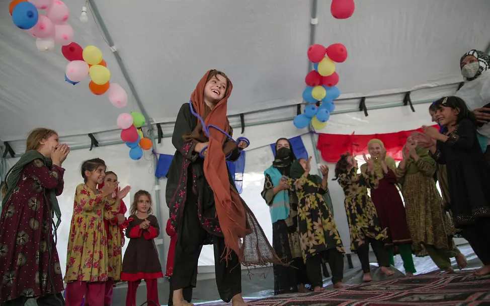 In geschützten Räumen können die vom Erdbeben betroffenen Kinder unbeschwert spielen und lachen. | © UNICEF Erdbeben einfach erklärt: Kinder tanzen und lachen in einem Zelt.