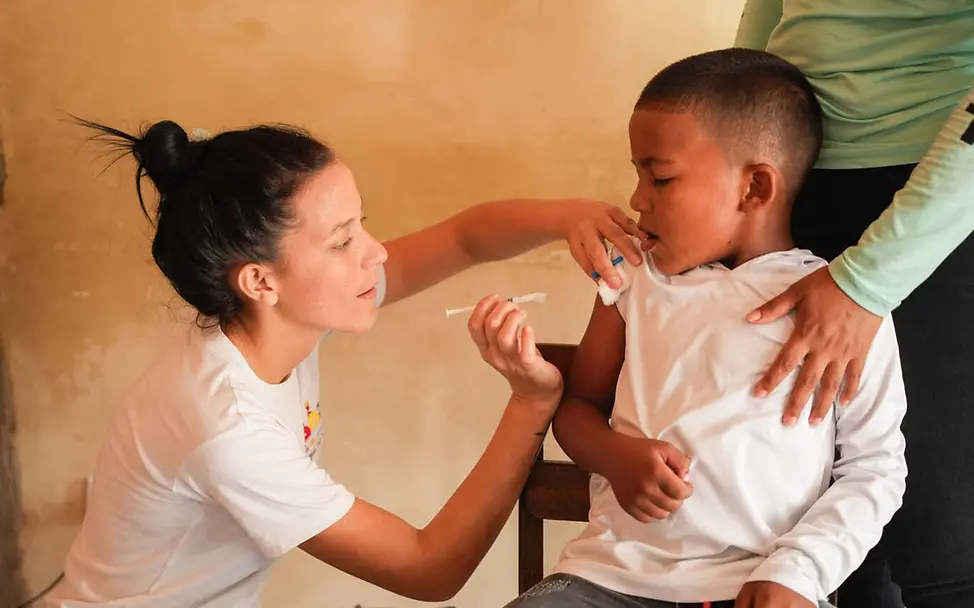 UNICEF impft Kinder auch in den abgelegensten Regionen der Welt | © UNICEF/Pocaterra Warum impfen: Eine Gesundheitshelferin impft einen Jungen in den Arm.