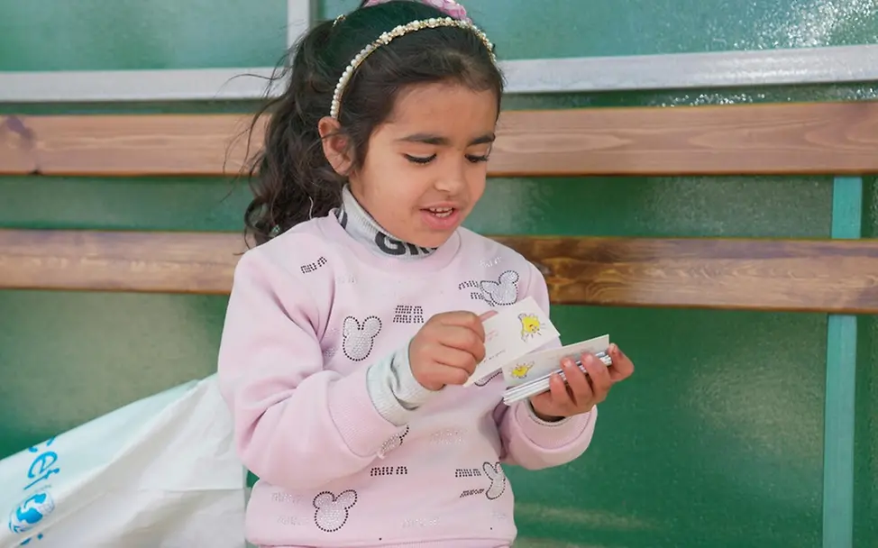 Kamar (4) erhält an der syrischen Grenze Joussieh ein Lernpaket. | © UNICEF/UNI975347/Shahan Auswirkungen des Konflikts im Nahen Osten: Kamar (4) erhält an der syrischen Grenze Joussieh ein Lernpaket.