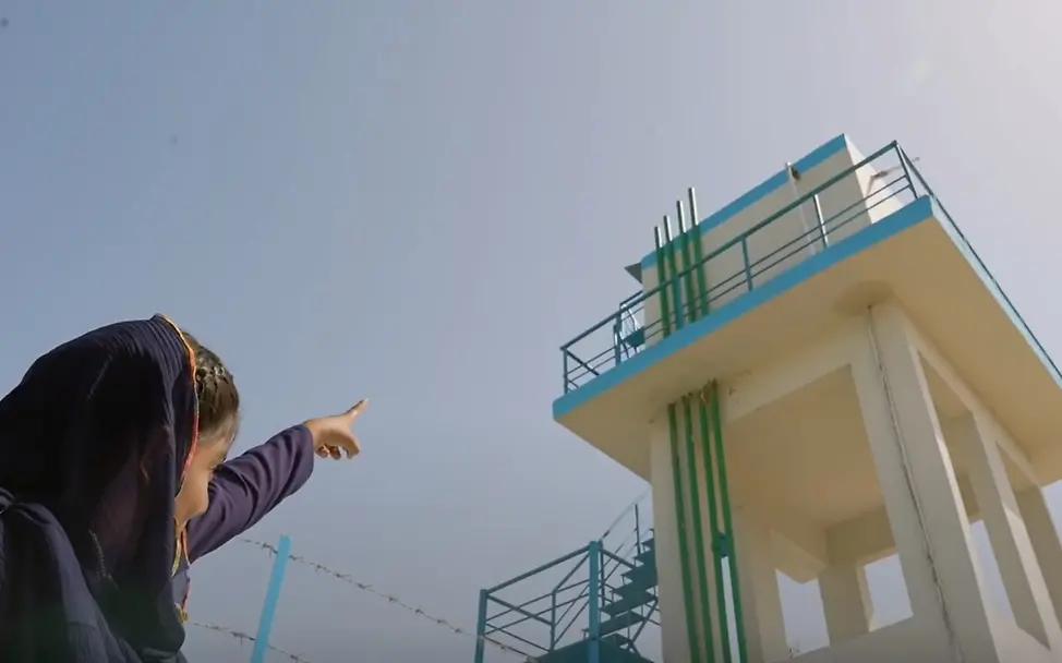 Sobh zeigt auf einen Wassertank, der die Gemeinde mit sauberem Trinkwasser versorgt. | © UNICEF Gute Nachrichten: Sobh zeigt auf einen Wassertank, der die Gemeinde mit sauberem Trinkwasser versorgt.