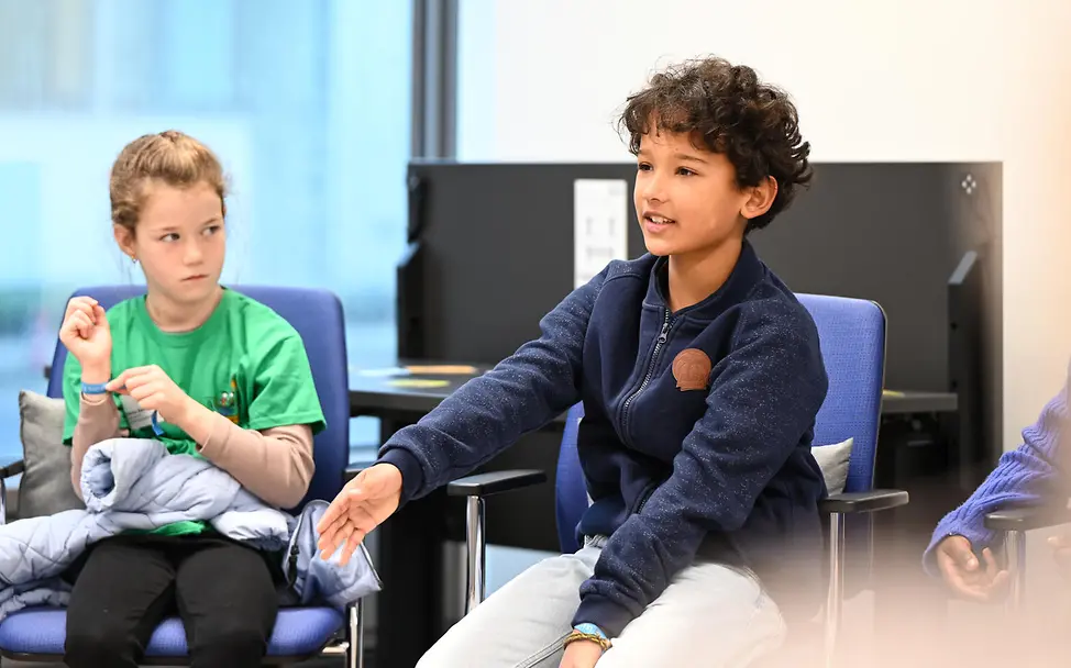 Grundgesetz einfach erklärt: Jeder Mensch darf nach dem Grundgesetz seine oder ihre Meinung sagen | © UNICEF/Sachse-Grimm Grundgesetz einfach erklärt: Zwei Kinder sitzen zusammen und sprechen.