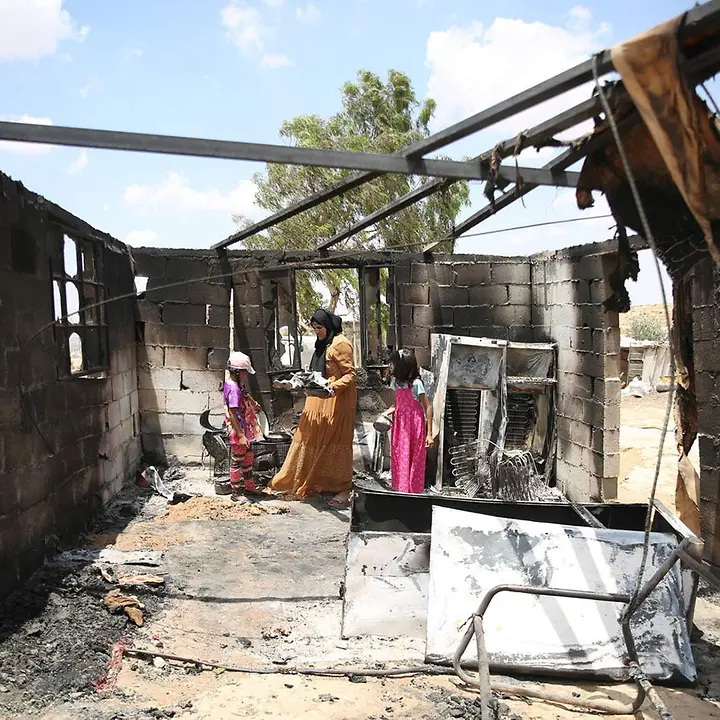 Eine palästinensische Familie sucht in einer Ruine nach Habseligkeiten. © UNICEF/Media Clinic Aufwachsen im Westjordanland: Eine palästinensische Familie in ihrem niedergebrannten Wohnhaus.