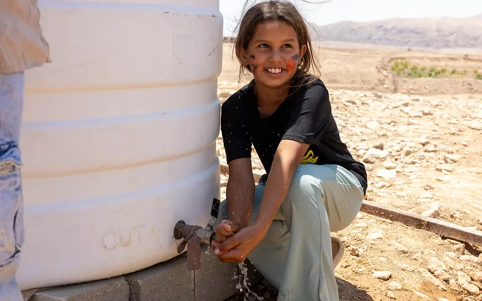 Ein Mädchen in einer Beduinengemeinschaft nahe Ramallah zapft Wasser aus einem UNICEF-Tank | © UNICEF/Izhiman Aufwachsen im Westjordanland: Ein Mädchen in einer Beduinengemeinschaft nahe Ramallah zapft Wasser aus einem UNICEF-Tank.