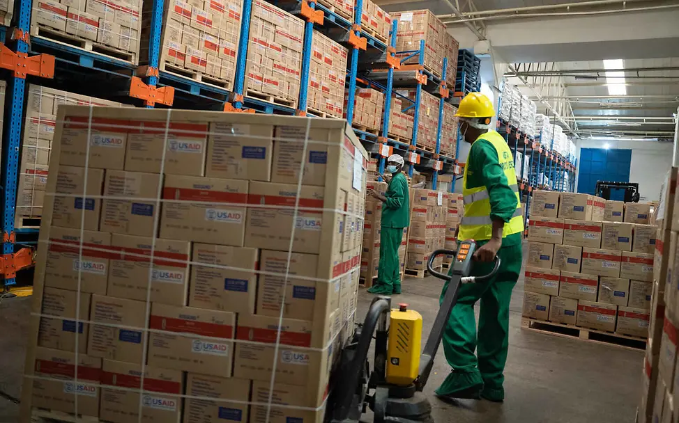 Die lokalen Fabriken sichern schnelle Verfügbarkeit und kurze Transportwege für die Erdnusspaste. | © UNICEF/Ekwam Erdnusspaste Herstellung: Mitarbeiter*innen bewegen Paletten mit Erdnusspaste im Warenlager.