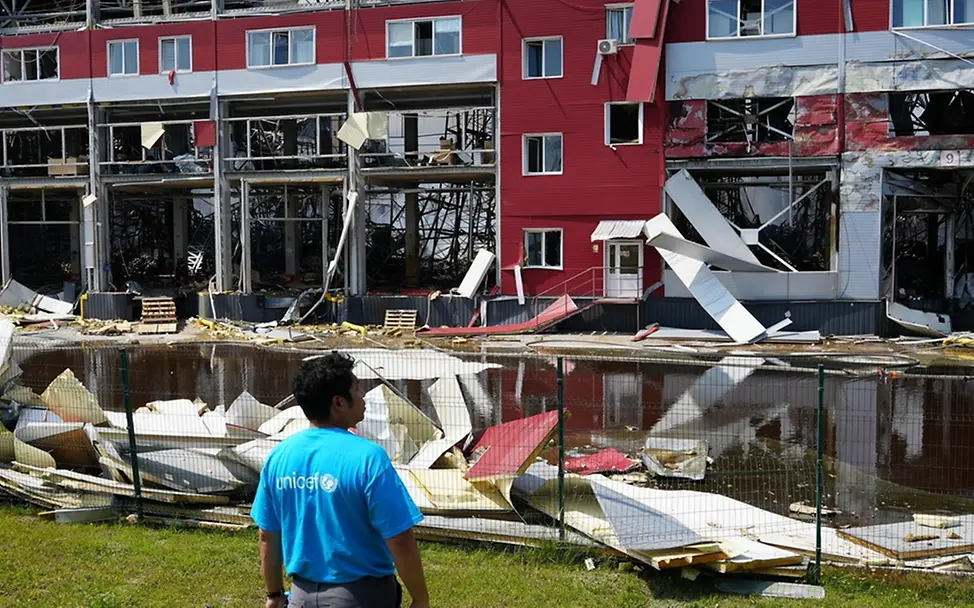 Ein UNICEF-Mitarbeiter steht vor dem beschädigten UNICEF-Lagerhaus in Bilohorodka. | © UNICEF/Milanes Ein UNICEF-Mitarbeiter steht vor dem beschädigten UNICEF-Lagerhaus in Bilohorodka.