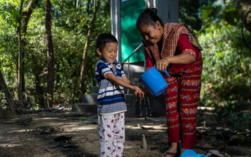 Mutter erklärt ihrem Sohn die hygienischen neuen Toiletten | © UNICEF/Mukut Hygiene: Mutter erklärt ihrem Sohn die neu aufgebauten Toiletten, indem sie ihm dabei hilft, sich zu waschen.