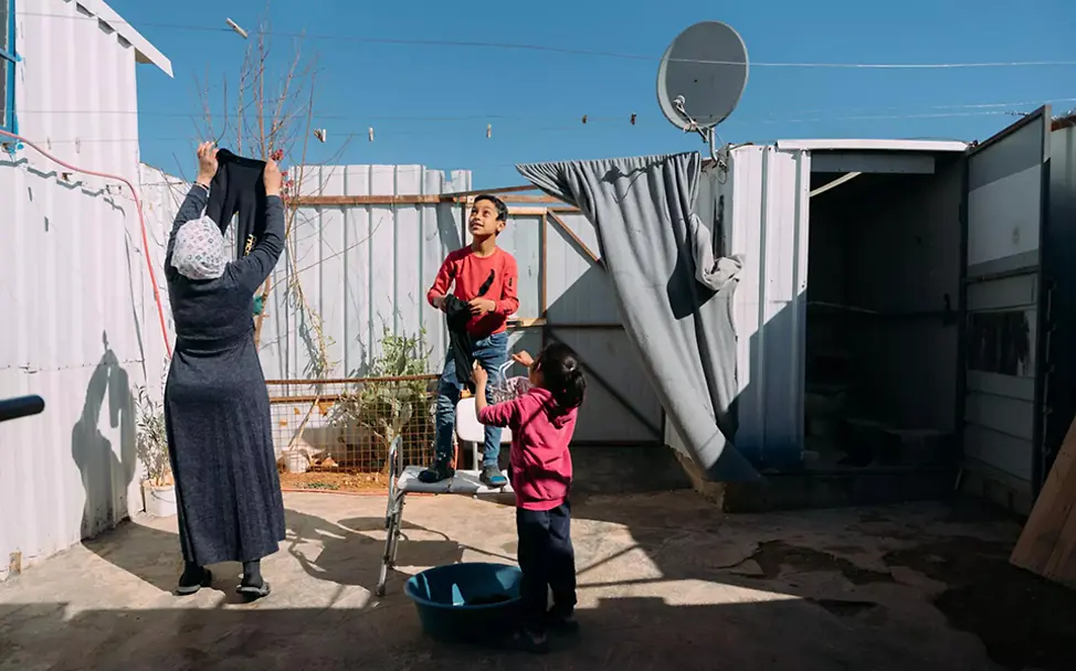 Da sie nun Zugang zu sauberen Wasser haben, kann diese Familie ihre Kleidung waschen | © UNICEF/Al-Safadi Aus Syrien geflüchtete Familie hängt in einem Flüchtlingscamp gemeinsam Wäsche auf.