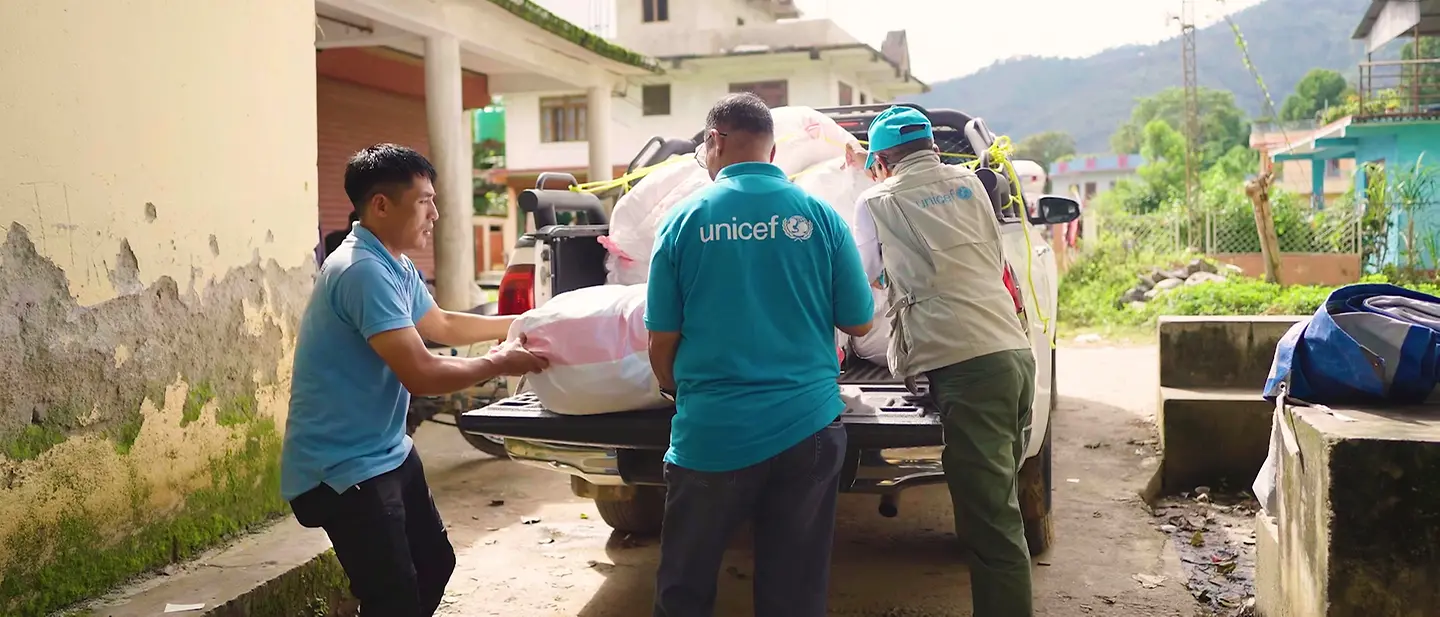 Sturzflut Nepal: UNICEF-Helfer laden Hilfsgüter aus. | © UNICEF Video-Still/UNI1013407 Sturzflut Nepal: UNICEF-Helfer laden Hilfsgüter aus.