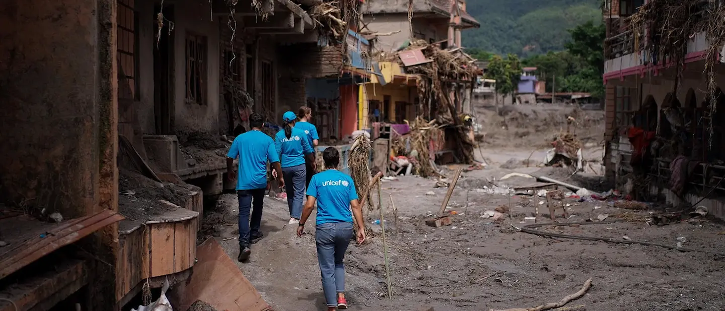 UNICEF-Helfer in von der Flut zerstörtem Gelände UNICEF-Helfer in von der Flut zerstörtem Gelände
