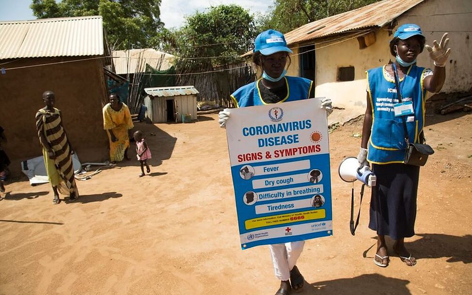 Corona im Südsudan: Zwei UNICEF-Helfer informieren über typische Symptome.