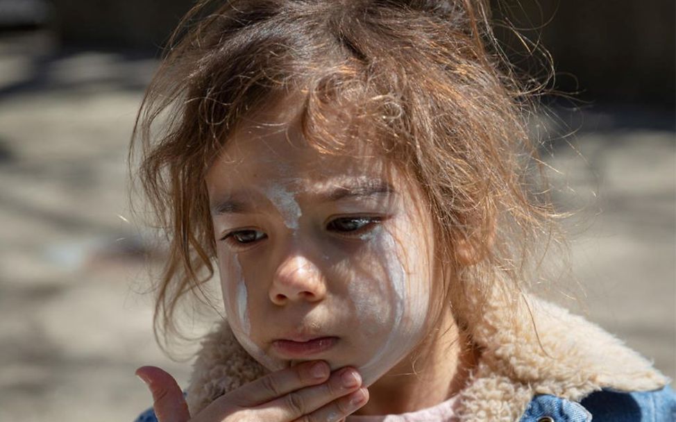 Hitze Kinder: Ein Mädchen cremt sich mit Sonnencreme ein